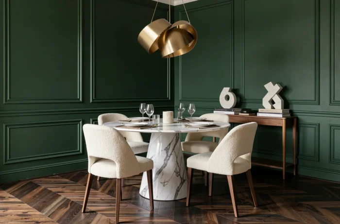 Salle à manger contemporaine avec table en marbre, chaises en bouclé ivoire et mur vert forêt avec moulures architecturales